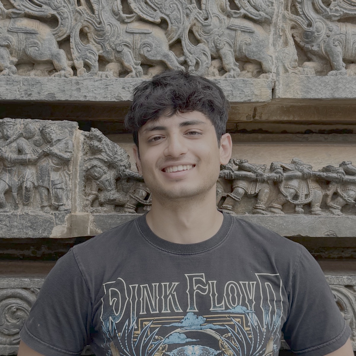 Kushan Raj smiling in front of a carved stone wall